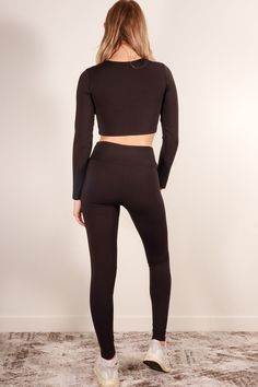 A polyamide elastane set featuring a long sleeve crop top, high waist leggings, and 4 way stretch from Capella Apparel Activewear Style Number: ATP71016 Fabric Details: 80% Polyamide, 20% Elastane Model is 5'9" and is wearing a Small Top - Bust: 13", Body Length: 14", Sleeve Length: 23" Bottom - Inseam: 27", Waist: 11.75", Total Length: 36.75" Black Elastane Crop Top For Fall, Black Elastane Athleisure Unitard, Black Elastane Unitard For Athleisure, Tight Long Sleeve Winter Activewear, Black Compression Elastane Unitard, Stretch Elastane Long Sleeve Unitard, Long Sleeve Stretch Unitard In Elastane, Long Sleeve Stretch Elastane Unitard, Long Sleeve Elastane Stretch Unitard