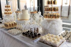 a table topped with lots of cakes and cupcakes