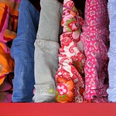 a red shelf filled with lots of colorful clothes