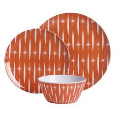 an orange and white dinnerware set with stars on it