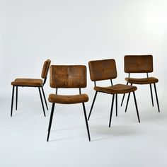 four chairs with black legs and brown upholstered backrests are lined up against a white background