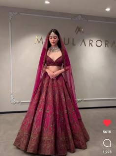 a woman in a red and gold bridal gown with her hands on her hips