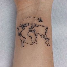 a small wrist tattoo with a world map and birds flying around the globe on it