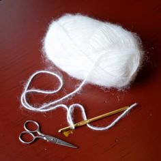 a pair of scissors and yarn on a table