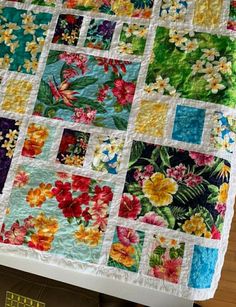 a quilted table runner with colorful flowers on it