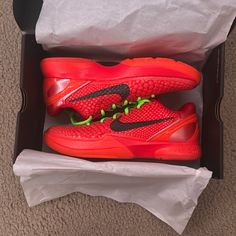 a pair of red nike shoes in a box