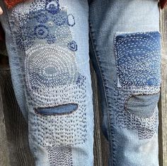 someone wearing blue jeans with an animal design on them