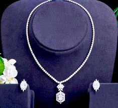 A beautiful two-piece bridal jewelry set with an elegant geometric vibe! Adorned with intricately faceted cubic zirconia that capture the light from every angle with a perfectly translucent appeal, the pieces are platinum plated for a flawless finish which enhances the intricate detailing and conveys a modern take on old elegance. Necklace: 17.5" (approx. 44.5) long, with a secure fold-over closure. Length of the pendant is 1.3" (approx. 3.3cm). Earrings: measure 0.75" (approx. 1.9cm) and come w Luxury Cubic Zirconia Necklace With Square Pendant, Luxury Classic Cubic Zirconia Bridal Sets, Luxury Vvs Clarity Cubic Zirconia Necklace, Luxury Silver Solitaire Necklace With Cubic Zirconia, Luxury Cubic Zirconia Necklaces For Engagement, Luxury Diamond-shaped Cubic Zirconia Necklaces, Elegant Cubic Zirconia Bridal Set With Diamond Cut, Elegant Cubic Zirconia Bridal Sets For Formal Occasions, Formal Cubic Zirconia Bridal Sets With Elegant Design