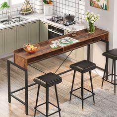 a kitchen table with three stools and a bowl of fruit on the counter top