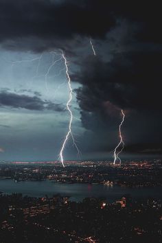 lightning strikes over the city at night time