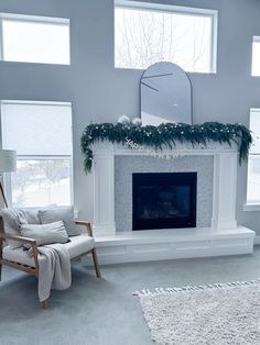 a living room filled with furniture and a fire place in front of a window covered in greenery