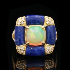 An 18k yellow gold opal, lapis and diamond ring. This ring was made by Cirari SR2536 Weight: 10.7 grams Size: 7.25 Brand: Cirari Opal Stone Dimensions: 8.75 x 8.75 mm approximately  Lapis Stone Dimensions: 9.0 x 5.0 mm approximately Diamond (16) Round Brilliant  Stone Dimensions: 1.20 - 1.30 mm approximately Color: G-H Clarity: VS2-SI1 Carat Weight: 0.14 ctw Luxury Yellow Gold Opal Ring With Gemstone Accents, 14k Yellow Gold Opal Ring With Gemstone Accents, Yellow Gold Opal Ring With Gemstone Accents, Luxury Multi-stone Opal Ring In 14k Gold, Luxury Blue Opal Ring With Gemstone, Luxury Blue Opal Gemstone Ring, Art Deco Yellow Gold Opal Ring, Lapis Stone, Tree Jewelry