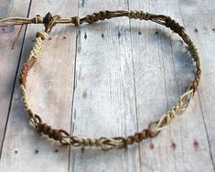 a close up of a rope bracelet on a wooden floor with an animal's head sticking out of it