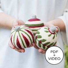 two ornaments in the shape of christmas balls are being held by someone's hands