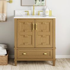 a bathroom vanity with two drawers and a mirror on the wall above it, next to a wicker basket