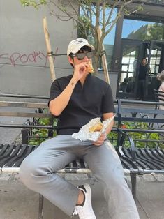 a man sitting on a bench eating food