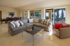 a living room filled with lots of furniture next to sliding glass doors and windows that look out onto the backyard