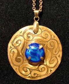 This graceful design is hand sketched on NuGold and then hand etched with Ferric Chloride. A piece of textured blue dichroic glass was added to be the focal point. The pendant is approximately 2 inches in diameter and comes with a brass chain that is 20 inches long. This pendant may be ordered with dichroic glass in other colors, please contact seller for available options. Blue Round Etched Jewelry, Blue Etched Round Jewelry, Artisan Blue Jewelry With Recycled Glass, Artisan Blue Recycled Glass Jewelry, Etched Blue Jewelry For Gift, Unique Blue Etched Jewelry, Unique Etched Blue Jewelry, Hand Sketch, Dichroic Glass