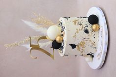 a white and black cake with gold decorations