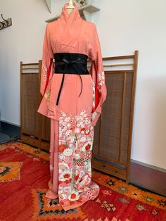 A beautiful, pink silk kimono. The  kimono is intricately patterned with peacocks, plum blossom, chrysanthemums, and lots of other flowers and patterns. There is also delicate gold embroidery and detailing. The silk itself is also woven with a pattern of flowers and traditional Japanese design. This would make a beautiful party dress, or would be a luxurious silk robe.  The condition of this kimono is good, especially for a vintage piece. There are a few marks. This Kimono is from Kyoto, Japan T Pink Silk Kimono For Wedding, Pink Silk Wedding Kimono, Pink Silk Long Sleeve Kimono, Pink Silk Kimono For Spring, Traditional Spring Wedding Kimono, Traditional Pink Kimono For Spring, Pink Kimono For Spring Wedding, Spring Wedding Pink Kimono, Traditional Silk Kimono With Floral Print