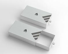 two white boxes with black and silver logos on the sides, one is open to reveal an empty box