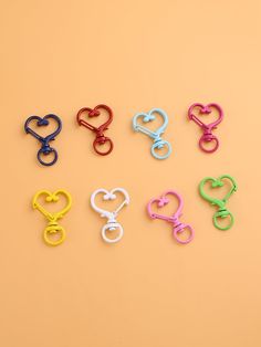 six pairs of scissors shaped like hearts on a yellow background with the words love spelled in different colors