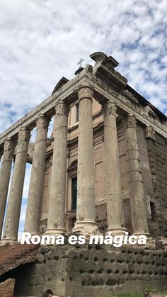 a man standing in front of an old building with columns and the words roma es magica written on it