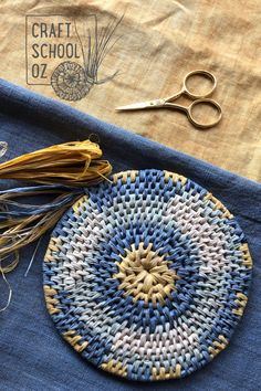 some yarn and scissors are laying next to a piece of cloth that has been woven on it