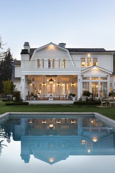 a large white house sitting next to a swimming pool