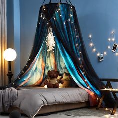 a bed with a canopy over it and lights on the wall above it in a bedroom