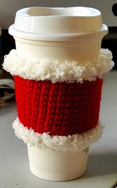 a coffee cup covered in red and white yarn