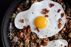 two fried eggs in a skillet with bacon on top