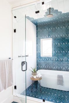 a bathroom with blue and white tiles on the walls, flooring and bathtub