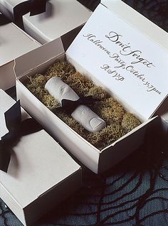 two small boxes with black and white bow ties in them