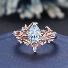 a ring with a pear shaped aqua blue topazte surrounded by small white diamonds