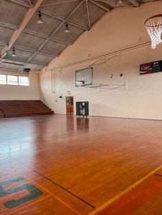 an indoor basketball court with hard wood flooring and white walls is pictured in this image