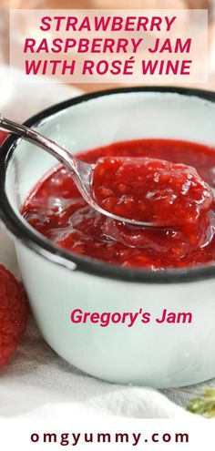 strawberry raspberry jam with rose wine in a white bowl on a table next to fresh raspberries