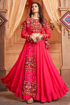 a woman standing in front of a wooden door wearing a red dress with colorful designs on it