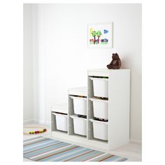 a white shelf with four bins and a stuffed animal on top in a child's room