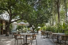 an outdoor dining area with tables, chairs and umbrellas