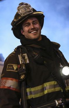 a smiling fireman with his helmet on