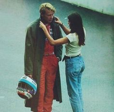 a man and woman standing next to each other with helmets on their heads as they look at each other