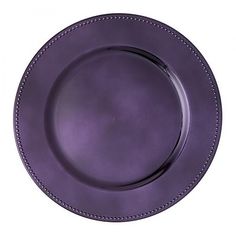 an empty purple plate with beading on the rim is shown in front of a white background