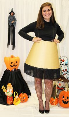 a woman in a halloween costume standing next to some pumpkins and jack - o'- lanterns