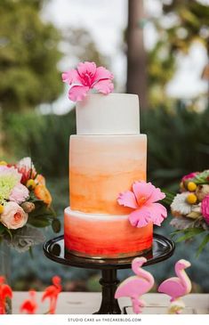 a multi - colored cake with pink flowers on top