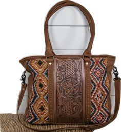 Hand Tooled Leather Shoulder Bag For Travel, Travel Shoulder Bag With Hand Tooled Double Handle, Brown Leather Hand Tooled Shoulder Bag, Hand Tooled Leather Travel Bag, Leather Hand Tooled Travel Bag, Brown Hand Tooled Shoulder Bag, Multicolor Hand Tooled Travel Bags, Brown Hand-tooled Satchel For Travel, Brown Hand Tooled Satchel For Travel