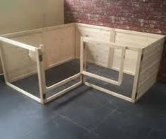 two wooden dog kennels sitting next to each other on the floor in front of a brick wall