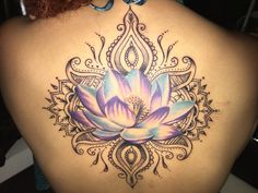 a woman's back with a lotus tattoo on it