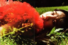 a woman laying in the grass with her eyes closed