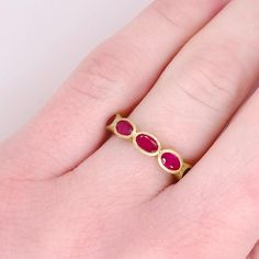 This 14 karat handmade ruby ring has five oval rubies set east to west. This dynamic design is gorgeous going across any finger. The five rubies have a total weight of 1.52 carats. The satin gold looks perfect when paired with high-polished rings. The details for this beautiful ring are listed below:Metal Quality: 14k Yellow GoldGemstone: RubyGemstone Number: 5Gemstone Shape: OvalAverage Gemstone Measurements: 4.8 millimeters x 2.8 millimetersGemstone Color: Ruby RedBand Width: 2.3 millimetersRi Three Stone Oval Ruby Ring, Ruby Band Ring, Ruby Bands, Dynamic Design, Ruby Ring, Beautiful Ring, Yellow Gold Rings, Bezel Setting, Beautiful Rings